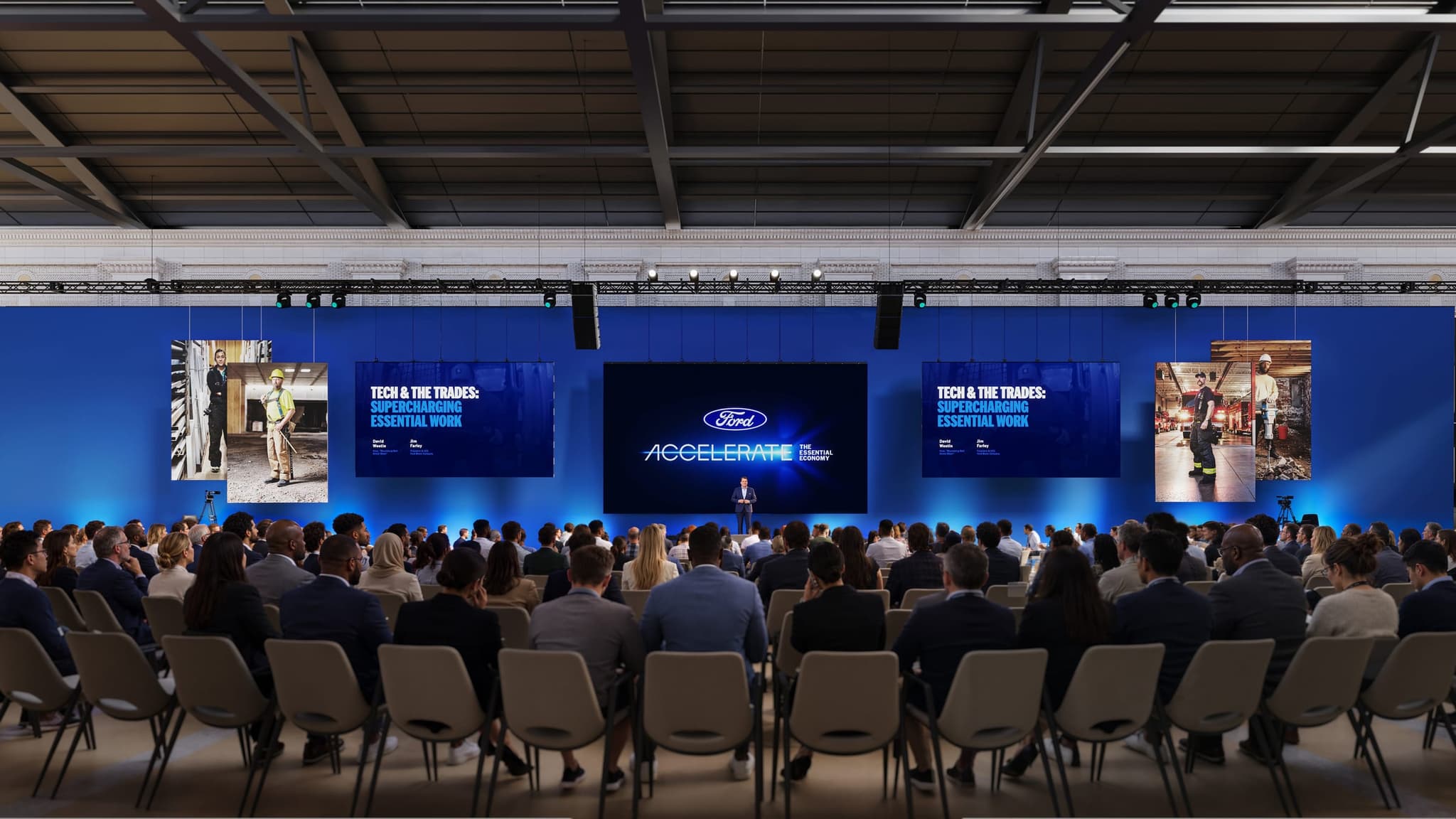 Render of the South Concourse at Michigan Central Station set for a keynote, with a wide blue stage wall, a central screen, flanking screens and a full seated audience.